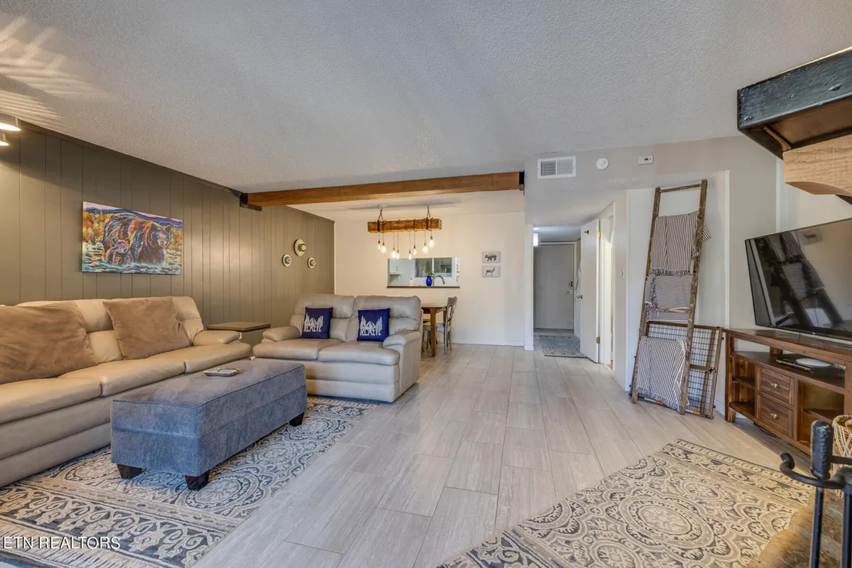 An inviting living area with a plush sofa, tasteful artwork, and an adjacent dining space—designed for both relaxing and entertaining guests in comfort.